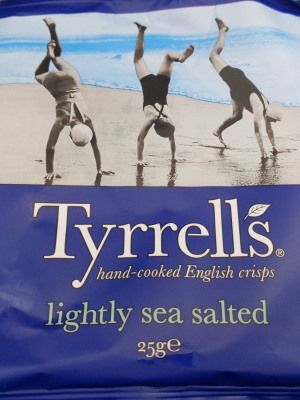 Eine Chipstüte mit Aufdrucke Tyrrells und einem Foto, welches drei Menschen am Strand zeigt, die Handstand machen