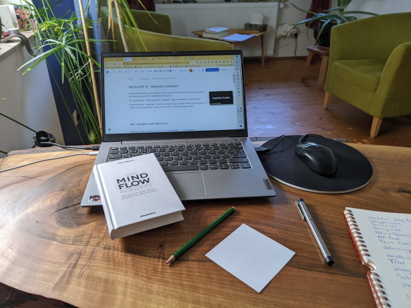 Schreibtisch mit Laptop und Buch